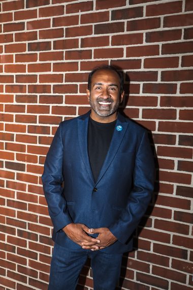 Rohit Bhargava smiling in a navy blazer against a brick wall